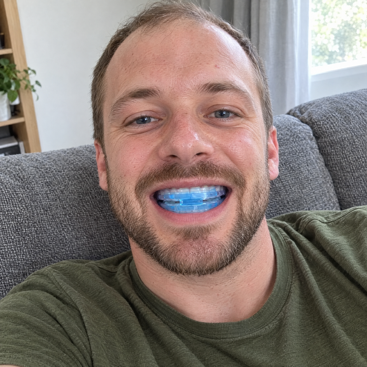 Man met de blauwe Snorrless beugel in op de bank